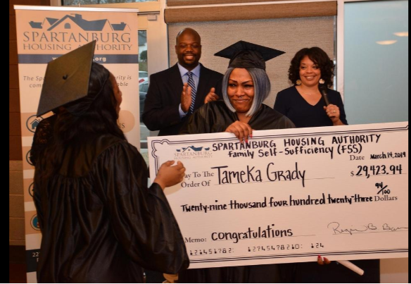 Tameka Grady holding a check