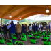 People gather under the pavilion, chairs with green bags attached are lined up neatly