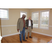Two men standing inside the property in an empty room with hardwood floors