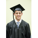 A smiling young man with a tie on in his cap and gown